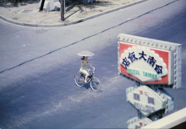 1970年，在台南大飯店的房間往街上望，看見一位撐著洋傘騎單車的妙齡女子正在穿越成功路