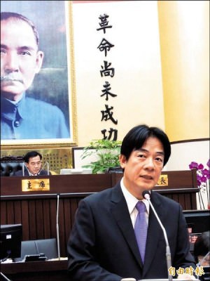 台南市長賴清德昨進議會報告，議長李全教坐在主席台，議事大廳上的「革命尚未成功」精神標語，格外耐人尋味。  （記者洪瑞琴攝）
