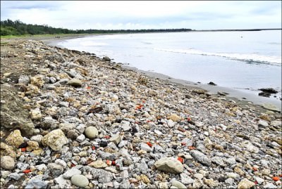 安平漁光島沙灘遍布廢棄石塊、磚塊，水利局下月進行整治。 （記者楊金城翻攝）