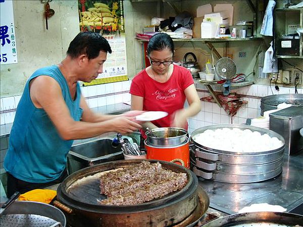 老闆與女兒，芋粿是將芋頭剉絲蒸熟後切成小塊在蒸籠內保溫